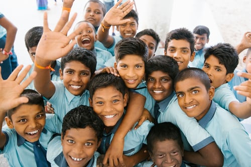 students smiling and hugging in big group